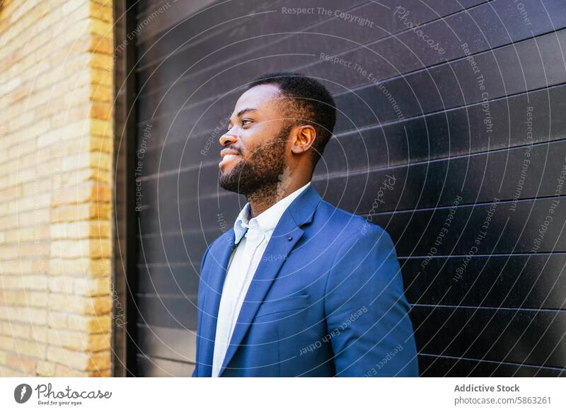 African American businessman smiling and looking away african american smile professional suit blue outdoors wall dark fashion confident casual exterior