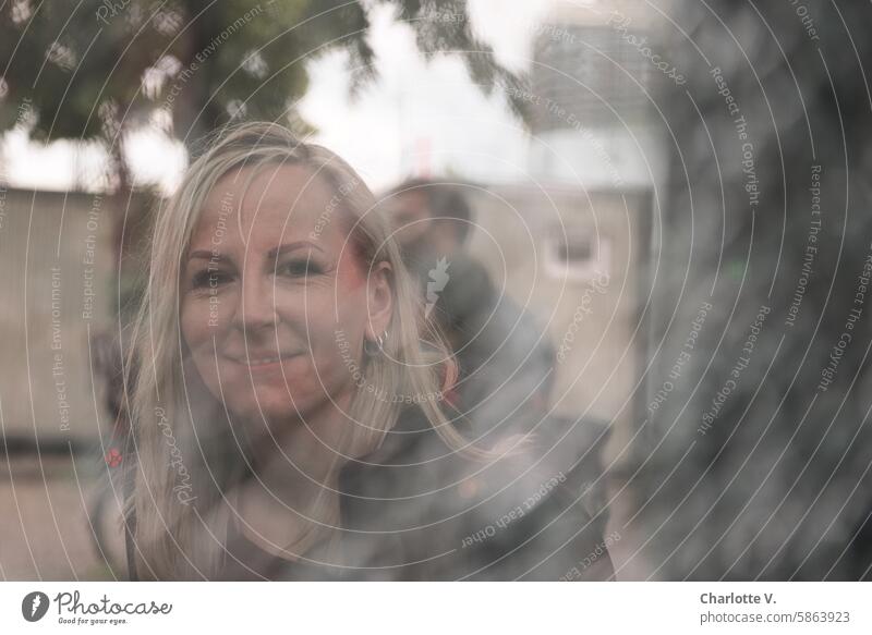Portrait of a smiling, blonde woman with blurs in the foreground portrait Human being person Woman portrait of a woman Face of a woman blurriness