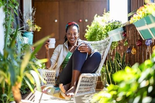 Beautiful woman relaxing on the balcony at home people joy black natural attractive black woman happiness happy real people mature adult daily life one person