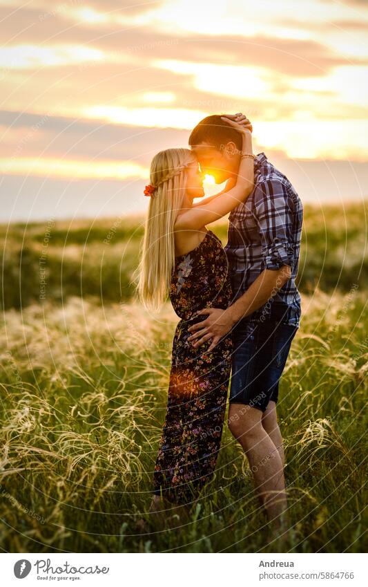 couple in love blonde girl and guy in the grass diversity evening family field fpchallengediversity green love story nature outdoors picnic sunset together walk