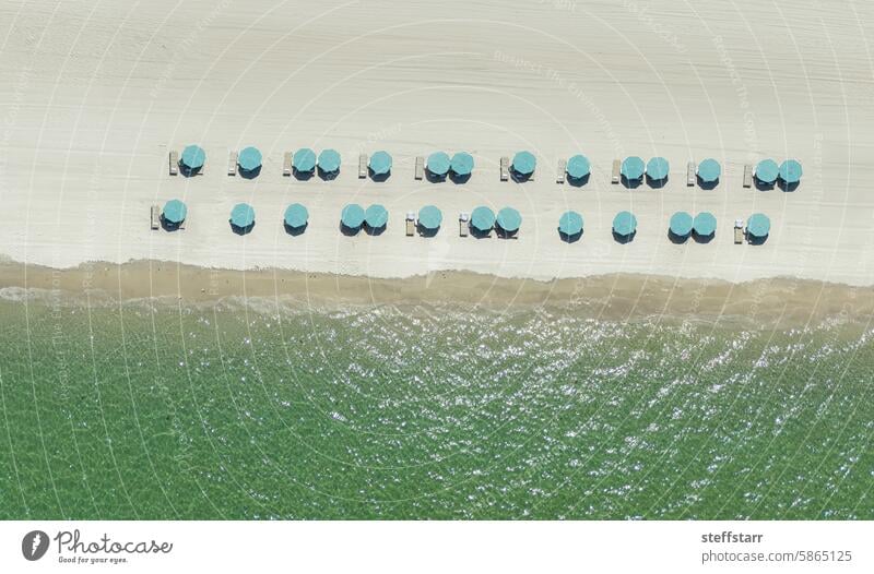 Light blue umbrellas from a drone over a beach Beach umbrella blue beach umbrella coast sea ocean Florida green water clear water coastal landscape aerial