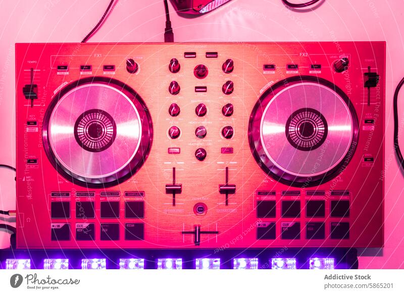 Vibrant pink DJ controller in detailed close-up shot dj music mixing deck knob button light audio equipment electronic party disco turntable sound nightclub