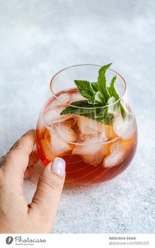 Refreshing Coke cocktail with mint leaves in elegant glass coke summer beverage drink chilled woman refreshment hand holding ice garnish stylish textured