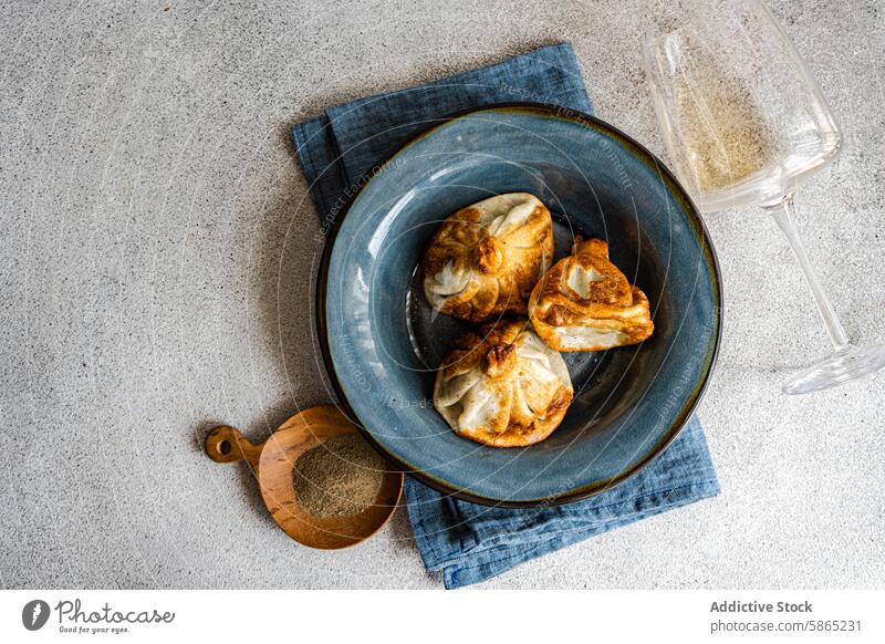 Golden-browned khinkali served on a ceramic plate georgian cuisine dumpling blue rustic aesthetic culinary traditional golden-browned artful arrangement dish