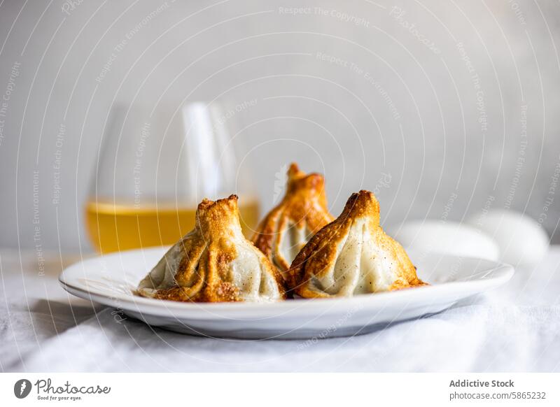 Traditional Georgian khinkali, beautifully presented on a plate georgian dumpling traditional cuisine white cooked golden crust food culinary authentic drink