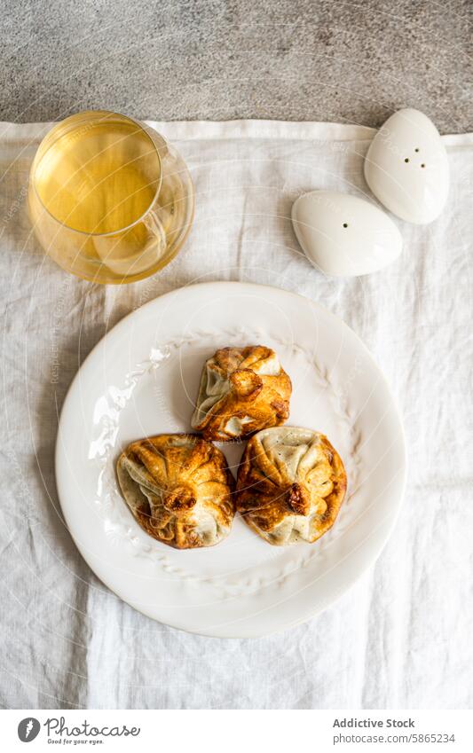 Traditional Georgian khinkali on a white plate with wine georgian cuisine dumpling traditional glass white wine rustic meal dish food salt shaker linen textile