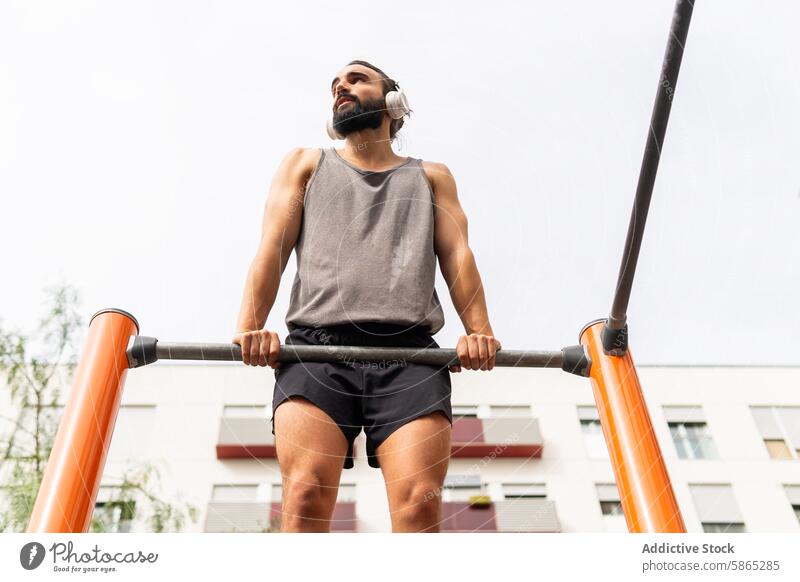 Man exercising at outdoor gym in Poblenou, Barcelona man poblenou barcelona fitness equipment strength determination urban strength training city health