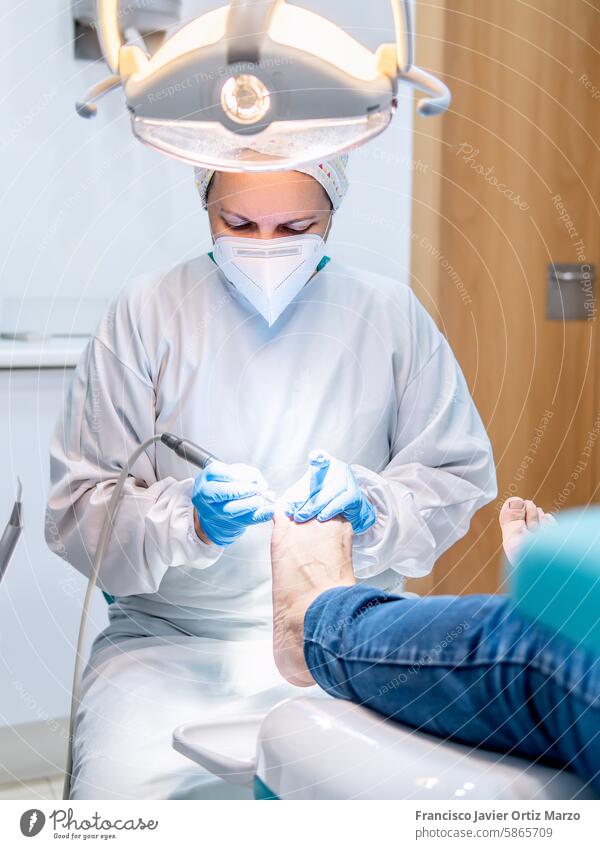 Female podiatrist doing chiropody in her podiatry clinic. Selective focus woman health nail doctor foot bunion callus medical patient pedicure care medicine