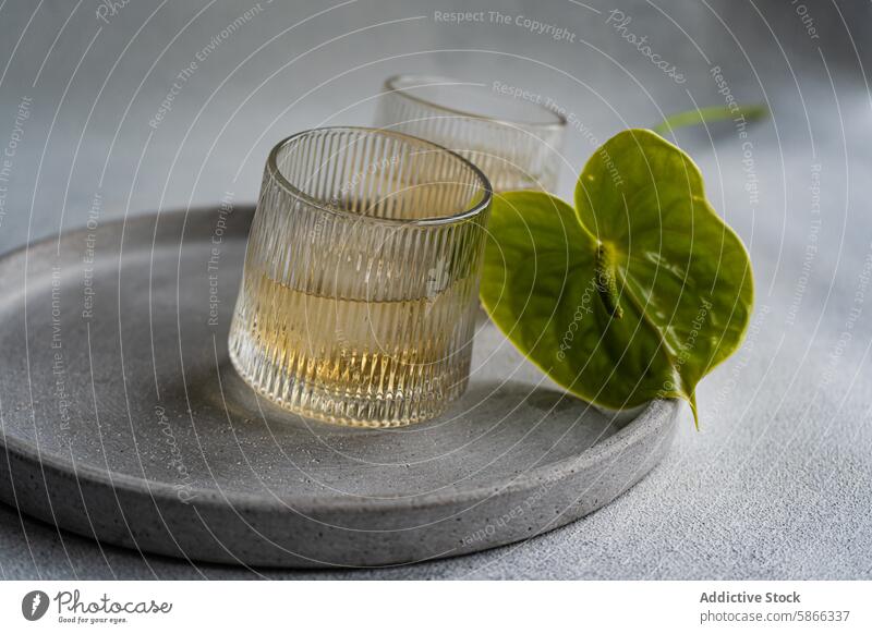 Elegant peach vodka cocktail with Anthurium on gray plate anthurium glass minimalist table setting beverage alcohol drink leaf elegant textured vibrant