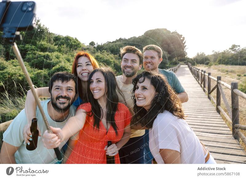 Group of friends enjoying beers on a wooden pathway selfie outdoor group casual afternoon nature social gathering bonding diverse diversity happiness leisure