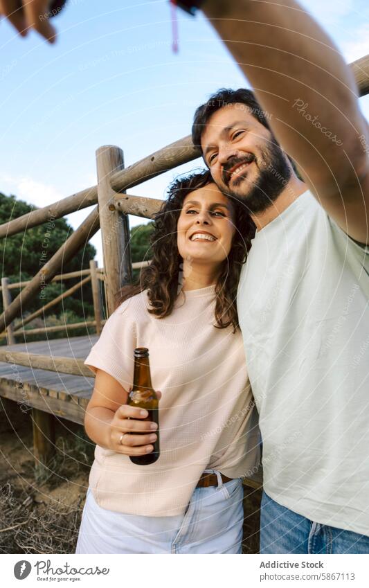 Friends enjoying beer outdoors in summer friend gathering smile laugh candid camera casual moment relaxation leisure social meeting warm weather enjoyment