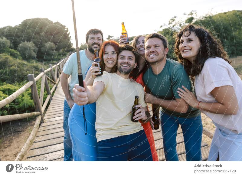 Group of friends enjoying beer together outdoors friendship gathering anonymous bridge laughter nature bonding unrecognizable faceless social leisure casual fun