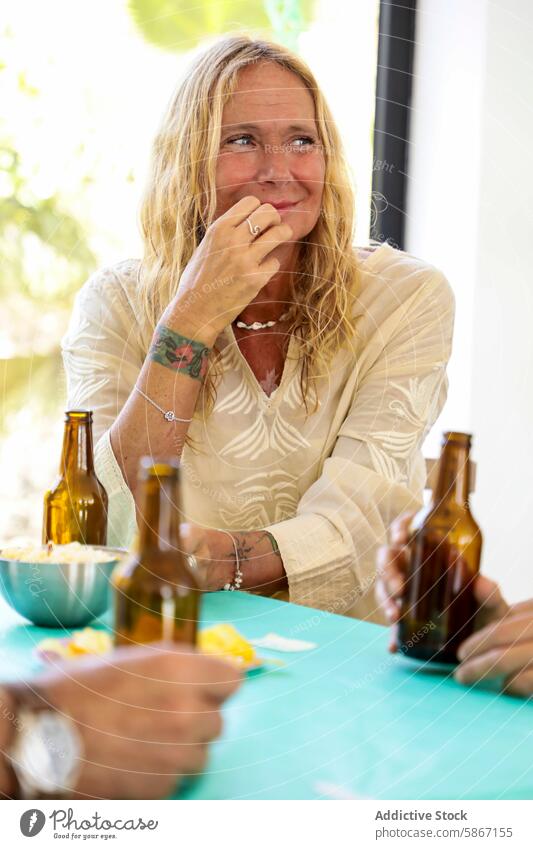 Elderly Woman enjoying a festive outdoor gathering with anonymous friends woman elderly party beer beverage conversation sunny day engagement smiling happiness