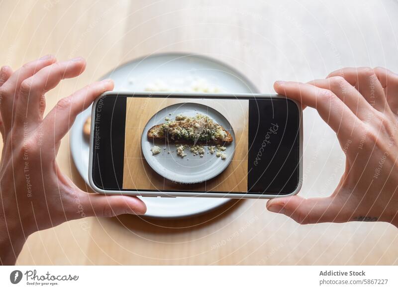 Cropped unrecognizable person photographing food with smartphone mobile phone photography technology gadget hands dish plate meal eating digital social media