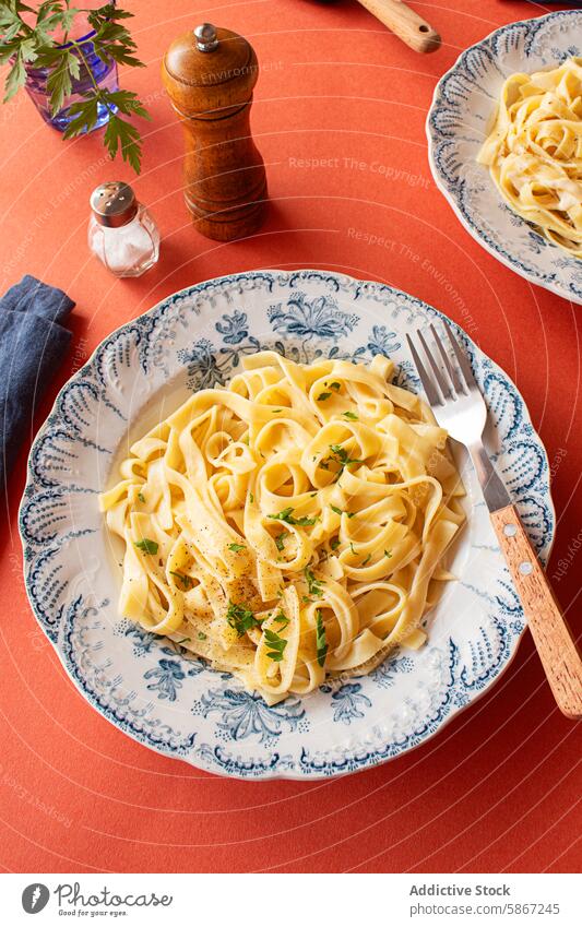 Delicious Italian pasta dish with creamy Alfredo sauce, garnished with parsley and parmesan mediterranean italian american herb styling soft restaurant homemade