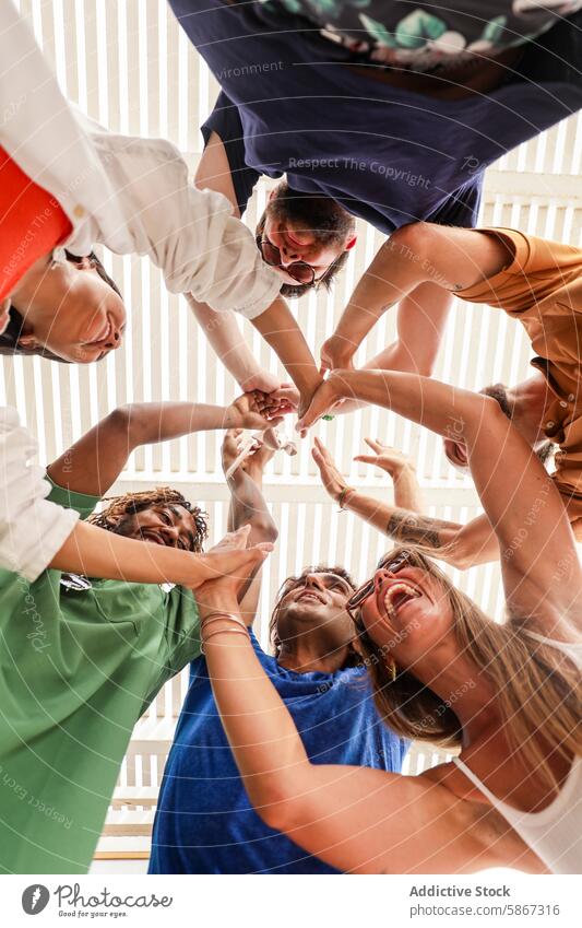 Diverse friends laughing together in a group circle friendship laughter multiethnic diverse hands heart fun smiling summer bonding happy outdoor sunlight unity