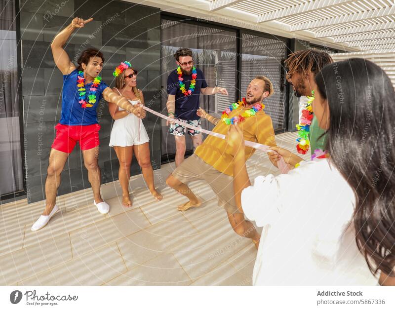 Friends enjoying a playful game at a summer party friends outdoor joyful teamwork sunny leisure fun competition hawaiian lei diverse multiethnic caucasian