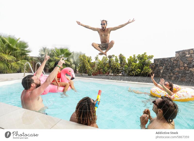 Friends enjoy a playful summer pool day friendship fun jumping diverse joyful party laughter swimming relax float inflatable flamingo cheers water outdoor