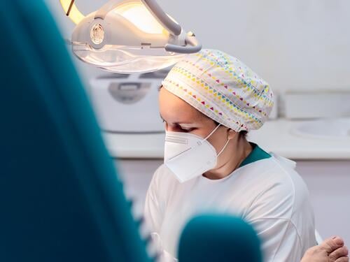 Female podiatrist doing chiropody in her podiatry clinic. Selective focus woman nail callus foot patient pedicure medicine bunion chiropodist health doctor care