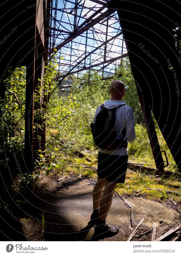 On the trail of the lost hangar Hangar Derelict Apocalyptic sentiment Change Ruin Transience Ravages of time Hall Man Rear view Backpack lost places Old Shadow