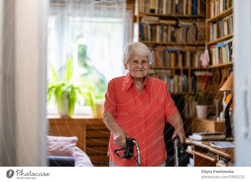 Senior woman with walker standing in her room smiling happy enjoying positive contented people senior mature female elderly home house old aging domestic life