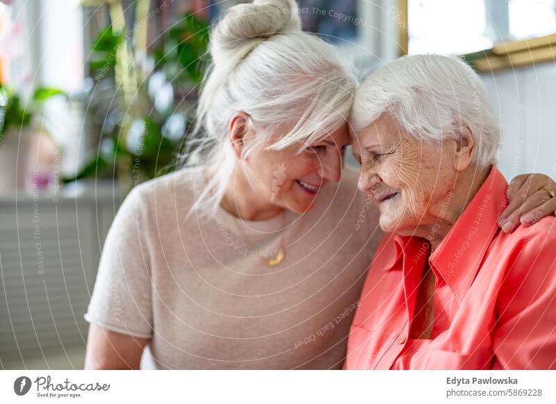 Happy senior woman with her adult daughter at home smiling happy enjoying positive contented people mature female elderly house old aging domestic life