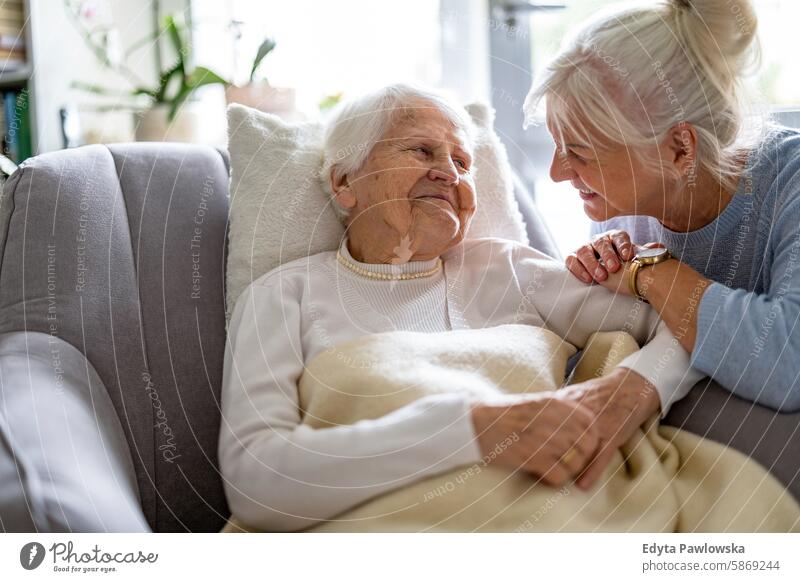 Happy senior woman with her adult daughter at home smiling happy enjoying positive contented people mature female elderly house old aging domestic life