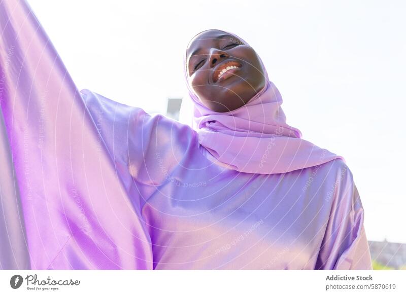 Serene moment in the park with a smiling woman in a hijab serene smile peaceful sunlight lifestyle happiness outdoor joyful summer sunny fashion lavender bright