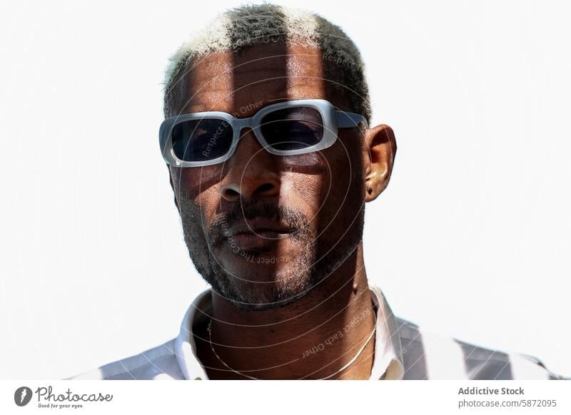 Mature man with sunglasses looking away confidently mature black portrait close-up blond hair bright sunlight day outdoor fashion male african american