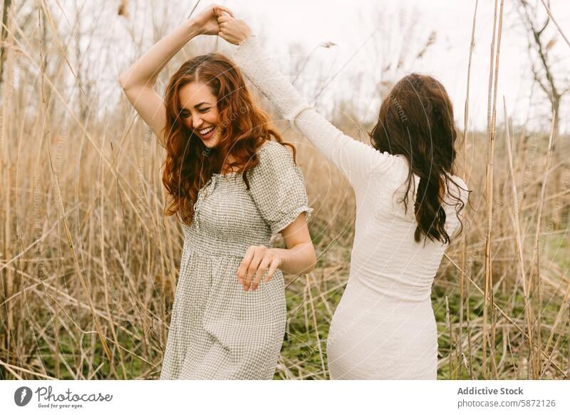 Joyful young women dancing in a natural outdoor setting woman friend anonymous dance joy nature smile playful freedom wood grass dress day happy lifestyle