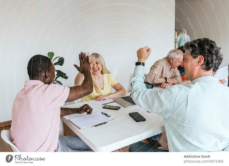 Diverse team celebrating and collaborating in a coworking space collaboration celebration high-five diverse multiethnic teamwork colleagues meeting project