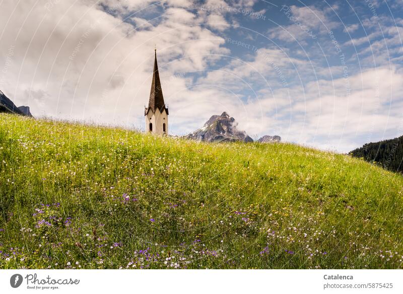 A church tower appears together with the mountain peak behind the grassy hill Landscape mountains Alps Peak Church spire Chapel Point Belief religion Meadow