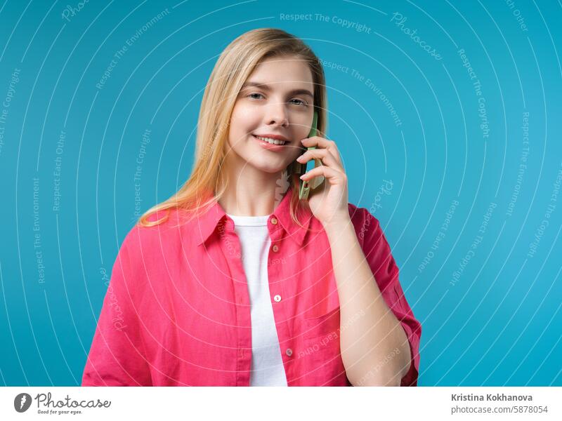 Attractive woman talking by phone, smiling. Young lady on blue background answering beautiful ask information attractive business call cell calling