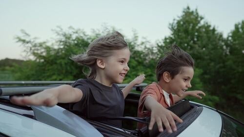 Funny Happy Little Boys Stands In Open Car Sunroof During Trip, Summer.Childhood adult air amazing arms auto boy boys breathing car carefree cheerful child