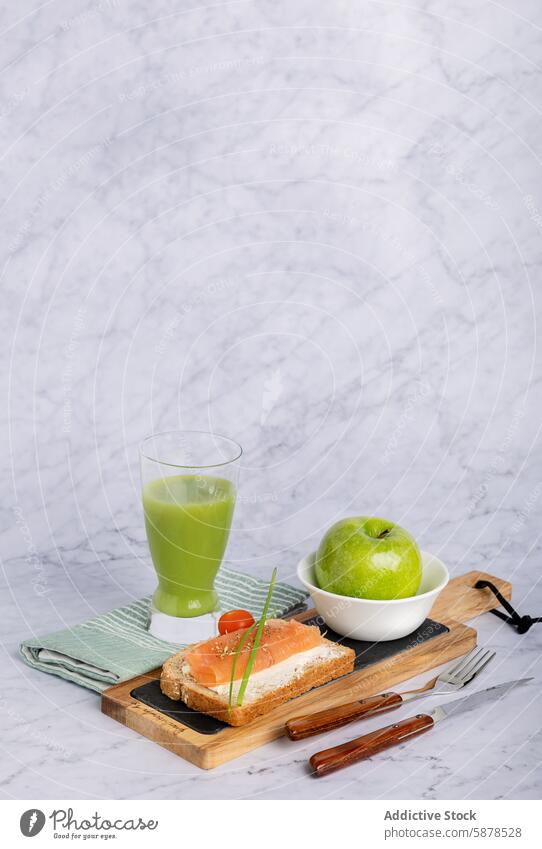 Wholesome meal of salmon on toast, cucumber and apple juice, and fresh apple food healthy wholesome green cherry tomato marble background nutritious green apple