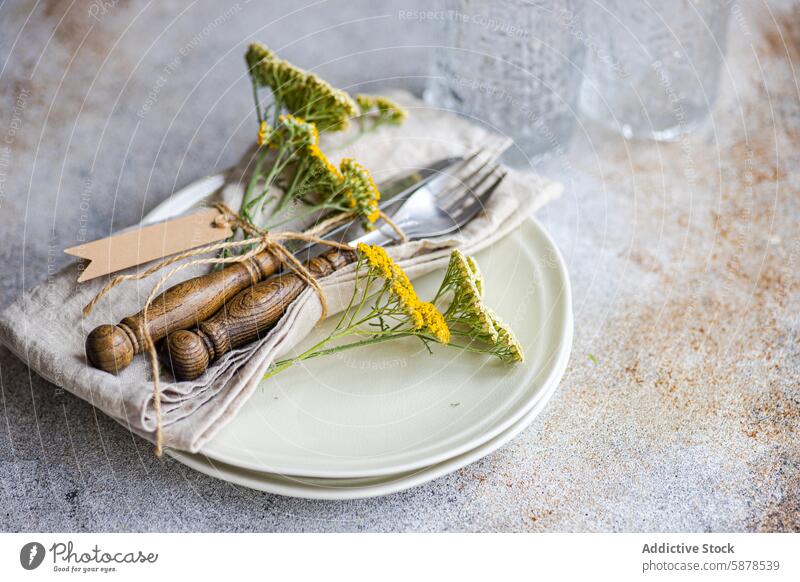 Rustic table setting with fresh wildflowers and vintage utensils rustic summer meadow achillea cream plate silverware fork knife arrangement decorative twine