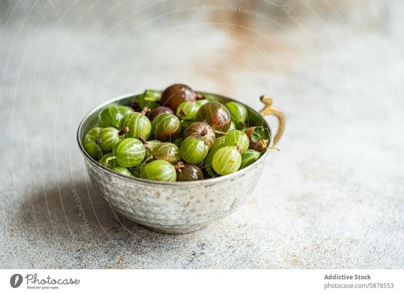 Bowl of organic gooseberries shot from above on textured surface gooseberry fruit bowl top view fresh natural green burgundy ripe healthy diet nutrition food