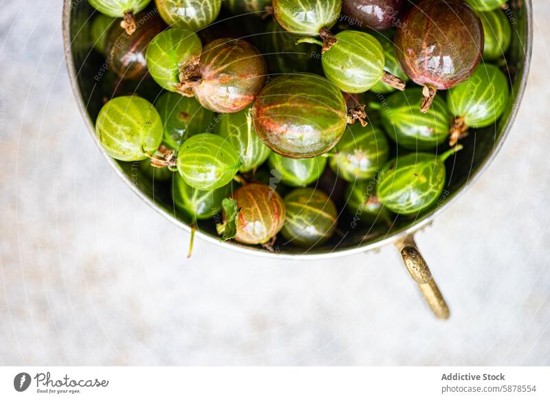 Top view of organic gooseberries in a vintage bowl gooseberry top view fruit metal rustic green purple fresh textured surface natural ripe healthy nutrition