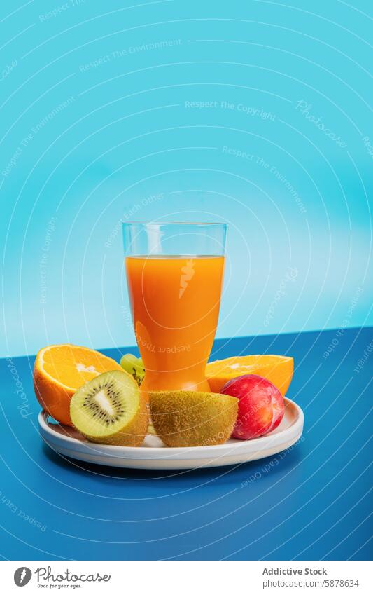 Colorful fruit spread with juice on vibrant blue background orange kiwi glass plate fresh colorful snack healthy citrus breakfast vitamin refreshment beverage