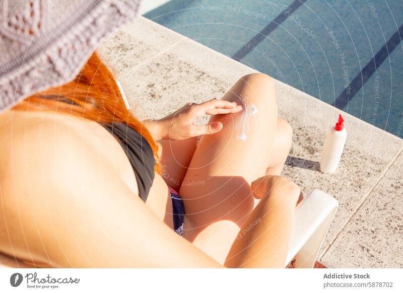 Unrecognizable woman Applying Sunscreen By The Pool In Summer pool unrecognizable summer sunscreen sunblock lotion skin care leisure outdoor sunny day poolside