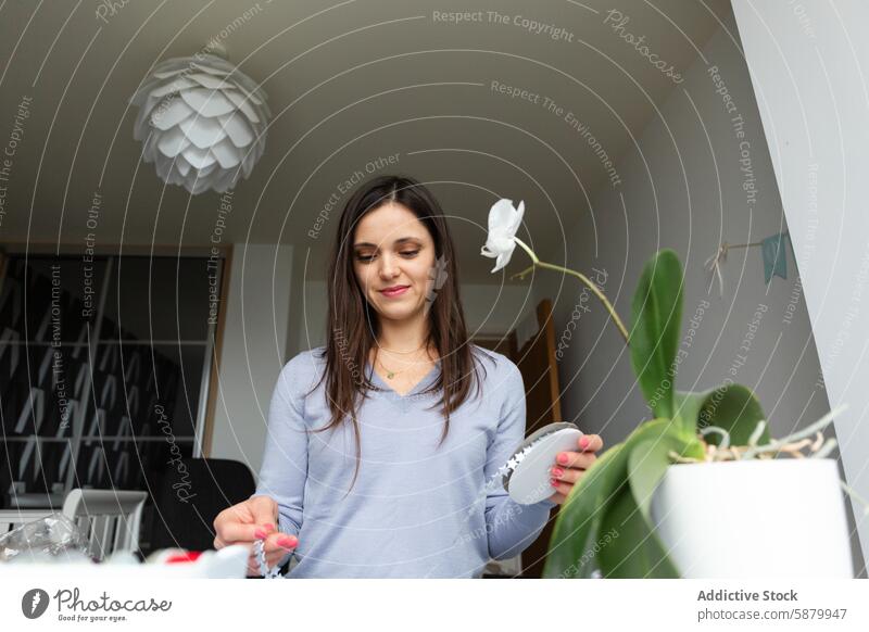 Young woman engages in paper crafting at home young creativity assembling decor modern room well-lit stylish inviting atmosphere project smile gently meticulous