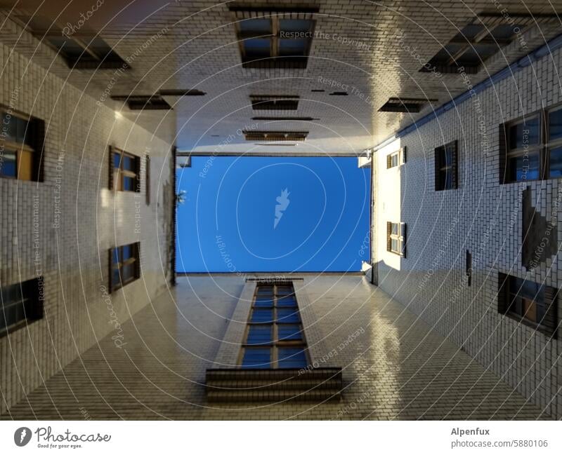 a piece of blue sky seen from an inner courtyard Interior courtyard Worm's-eye view Sky Facade Window Town Sky blue Apartment Building Upward Wall (building)