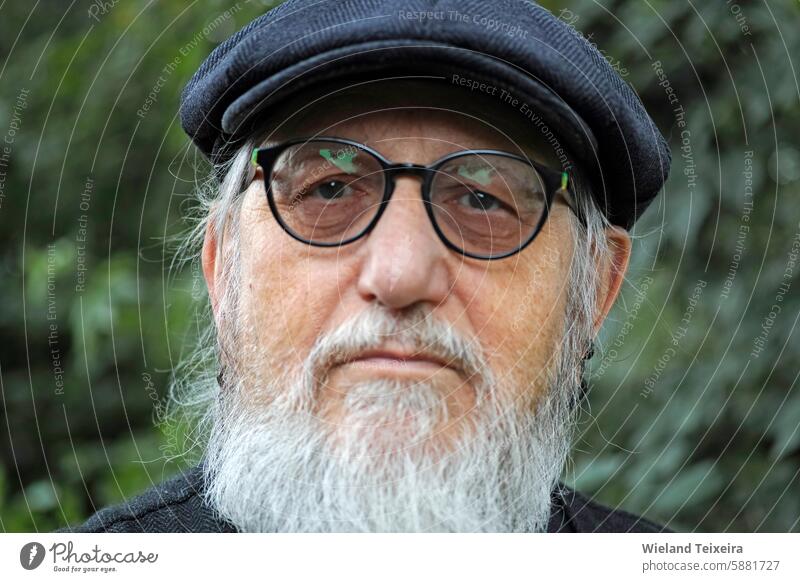 Portrait of a senior man with a stylish flat cap looking seriously into the camera black design vintage aged closeup elegant style hat caucasian retro portrait