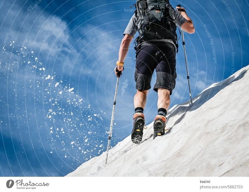 A man climbs up a snow-covered mountain hike Snow Hiking boots splash hikers Mountain voyager Vacation & Travel Trip Adventure Hiking trip Exterior shot Tourism