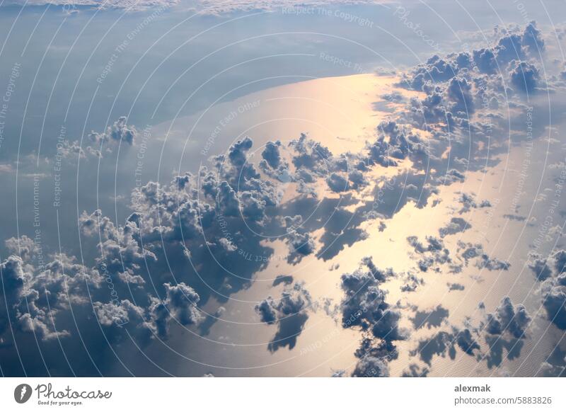 Beautiful view from window of plane flying over clouds and sea surface sky water sun ray cloudscape blue panorama landscape clouds background open space weather