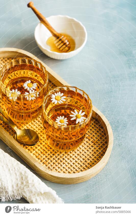 Two glasses of chamomile tea on a wooden serving tray. Hot drink. camomile tea Camomile blossom Tea glass Wood Table Herb tea Herbal medicine Healthy Eating