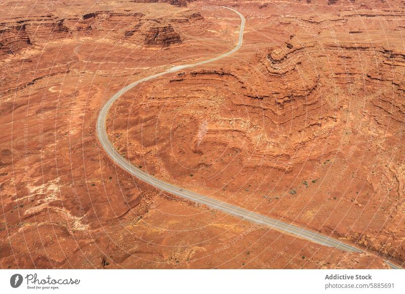 Aerial view of a winding road through Valley of the Gods, Utah aerial valley of the gods utah landscape red rugged natural beauty vast earth terrain desert arid