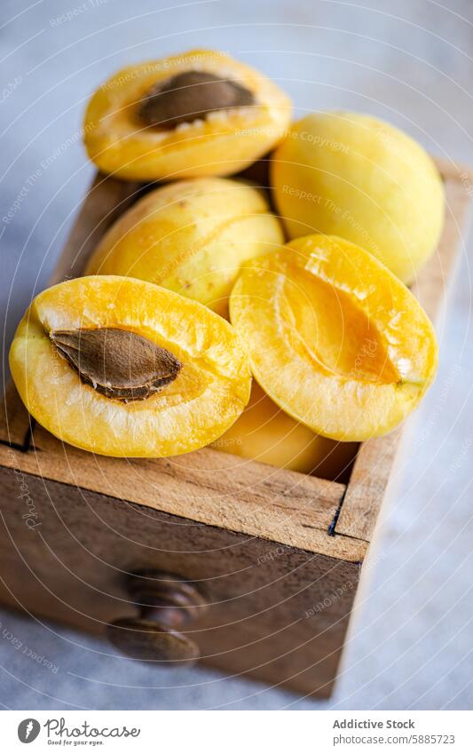 Fresh yellow nectarines in a wooden drawer fruit vibrant juicy fresh halved whole rustic summer seasonal nutritious healthy natural ripe seed flesh food