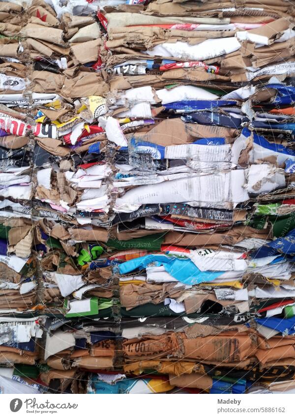 Colorful compressed cardboard boxes and packaging for recycling in a dumpster in the parking lot of a supermarket in Oerlinghausen near Bielefeld on Hermannsweg in the Teutoburg Forest in East Westphalia-Lippe