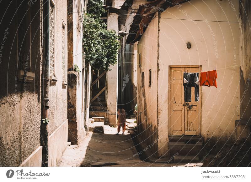 Peace and quiet in the narrow alley Alley Old town Facade Sunlight Shadow Laundry Authentic garments scenery Weathered Exotic Africa Kenya Mombasa